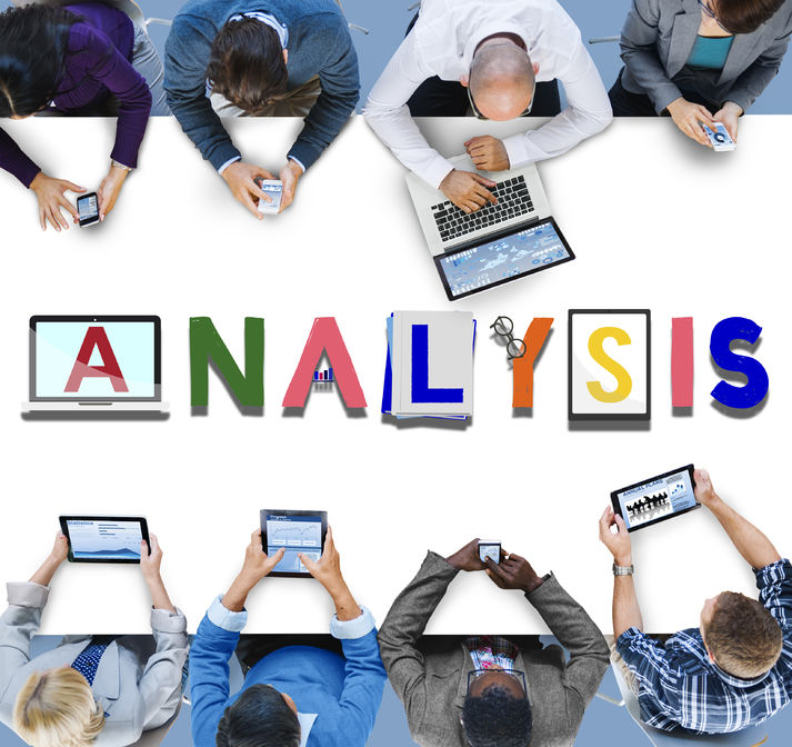 Mentoring Is More than the Match 7 Office workers sitting around a table on laptops, cell phones and Ipads analyzing a mentoring strategy. Analysis analytics strategy insight data concept.