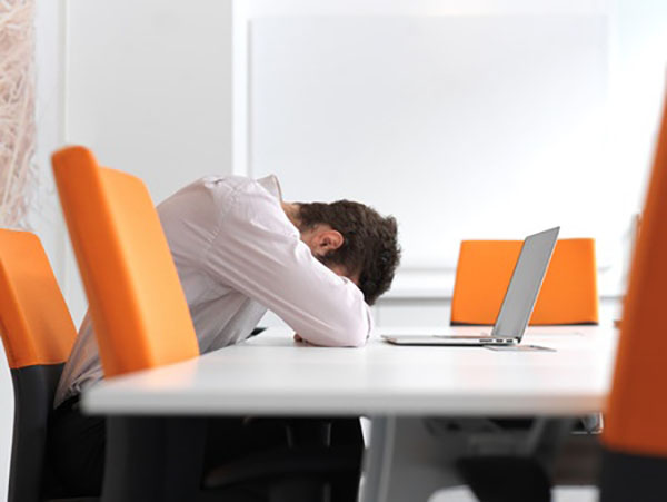 5 Mentoring Program Pitfalls 4 A frustrated and stressed out business man sitting alone at office meeting room and working on laptop computer.