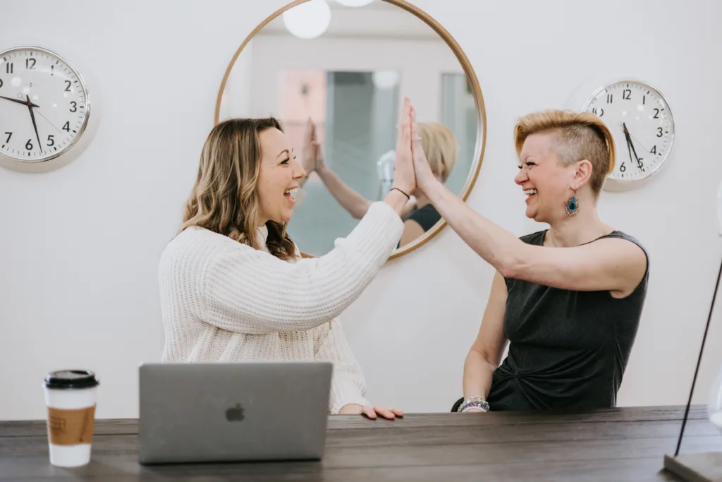 What Is the Employee Life Cycle? 6 Two employees highfiving to celebrate a successful mentoring relationship.