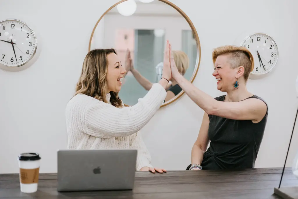 What Are Employee Resource Groups (ERGs)? A Comprehensive Guide for Getting Started 6 Two women in an women's employee resource group giving each other a high five.