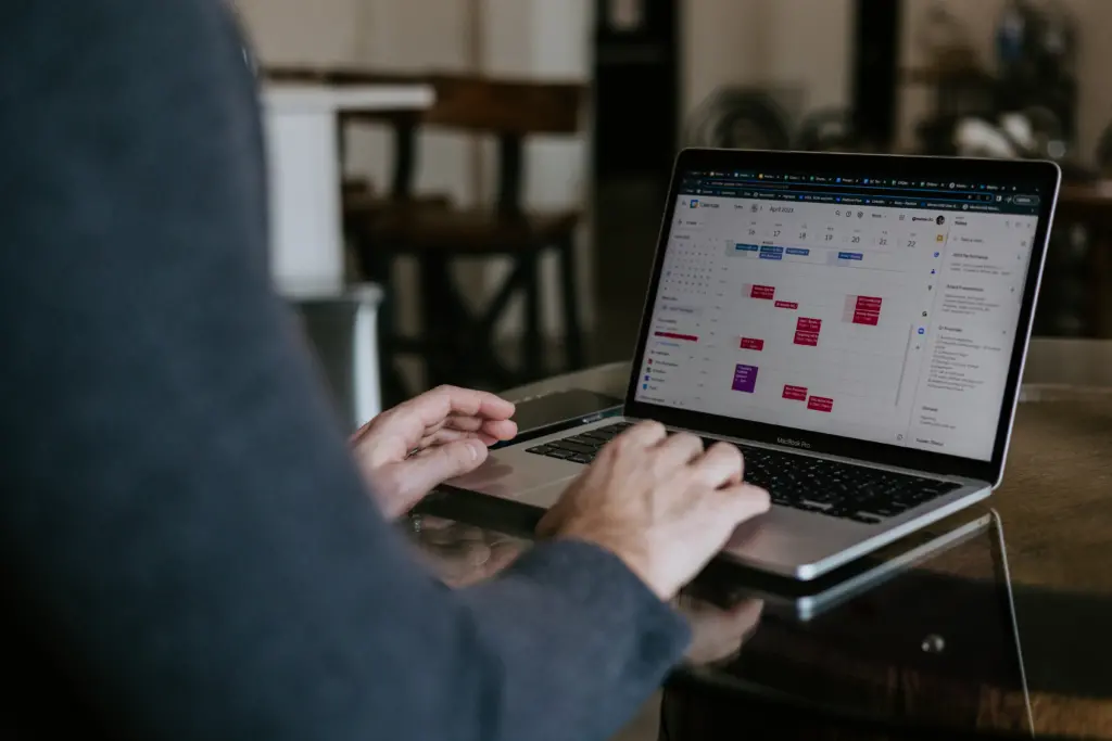 Which Mentor Matching Option Is Right for You? 5 Image of a leader sitting at a computer with a calendar open on the screen.