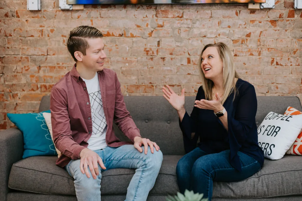 Career Mentoring: Critical Elements for Success 6 Man and woman on a couch discussing career mentoring advice.