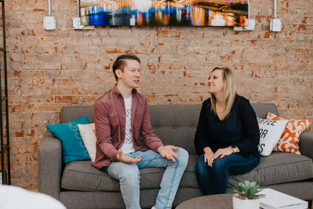 How to Understand and Support Neurodiversity in the Workplace 7 Two workers in an office sitting at a table discussion neurodivergent workplace policies.