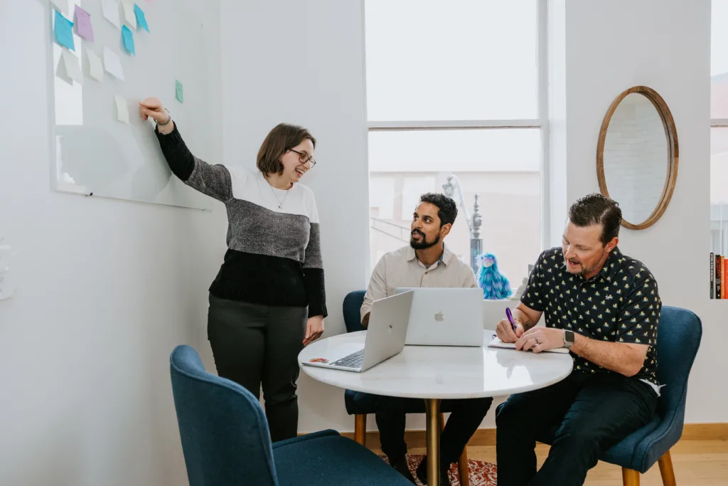 5 Employee Development Strategies that Will Increase Retention 11 Group of employees in a conference room discussing career development options.