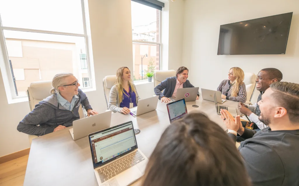 Inclusive Culture: How to Create an Inclusive Workplace Culture 7 Team meeting in a conference room with an inclusive culture represented by men and women of different backgrounds.