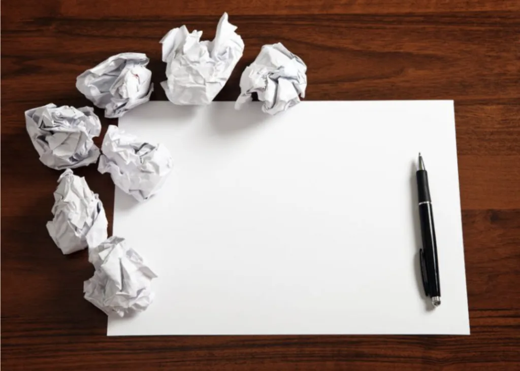 5 Mentoring Program Pitfalls 5 A blank piece of paper with a black ink pen laying beside is and a seven crumpled up pieces of paper laying around it.