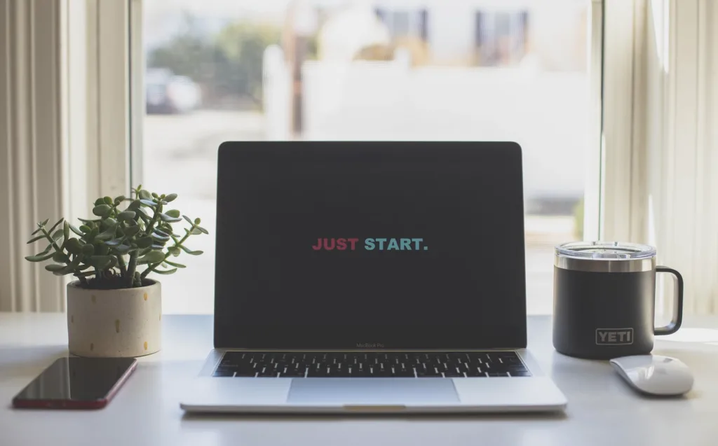 How Do I Design a Mentoring Program? 5 Home office setting with a laptop computer with the words "Just Start" on the screen.