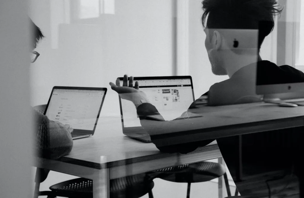 People Development: Your Complete Guide + Examples 6 Learning culture with employees talking in front of computer.