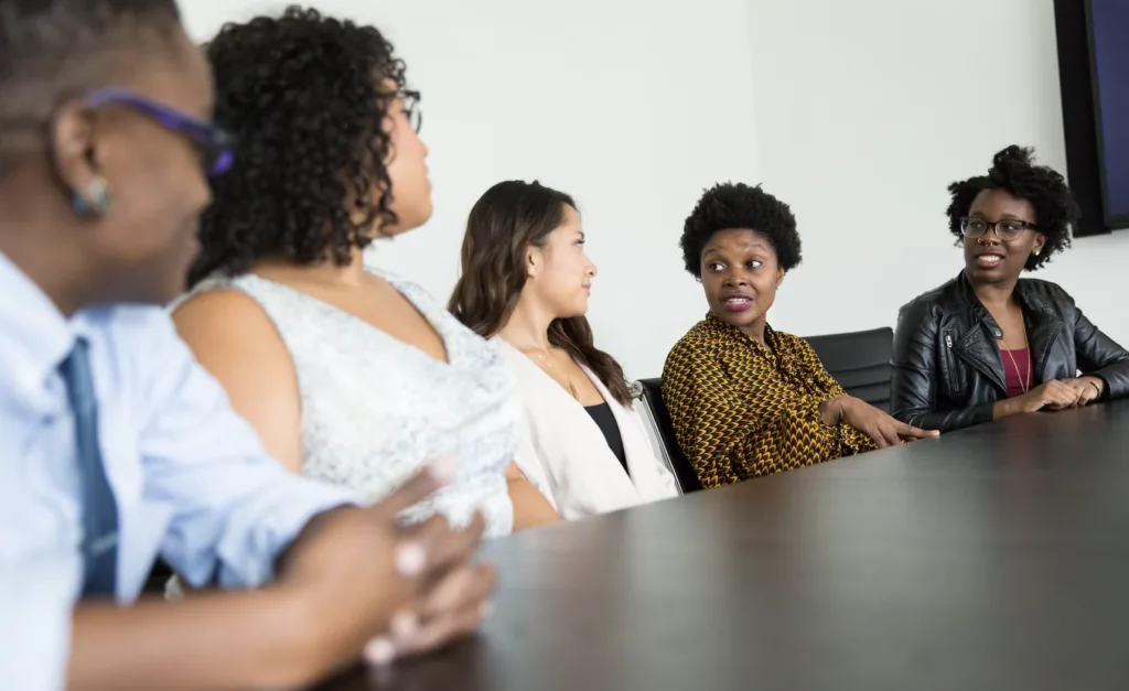 Reverse Mentoring: 11 Tips for Making It Work 6 Reverse mentoring with a group of BIPOC employees meeting and discussing around a conference table.