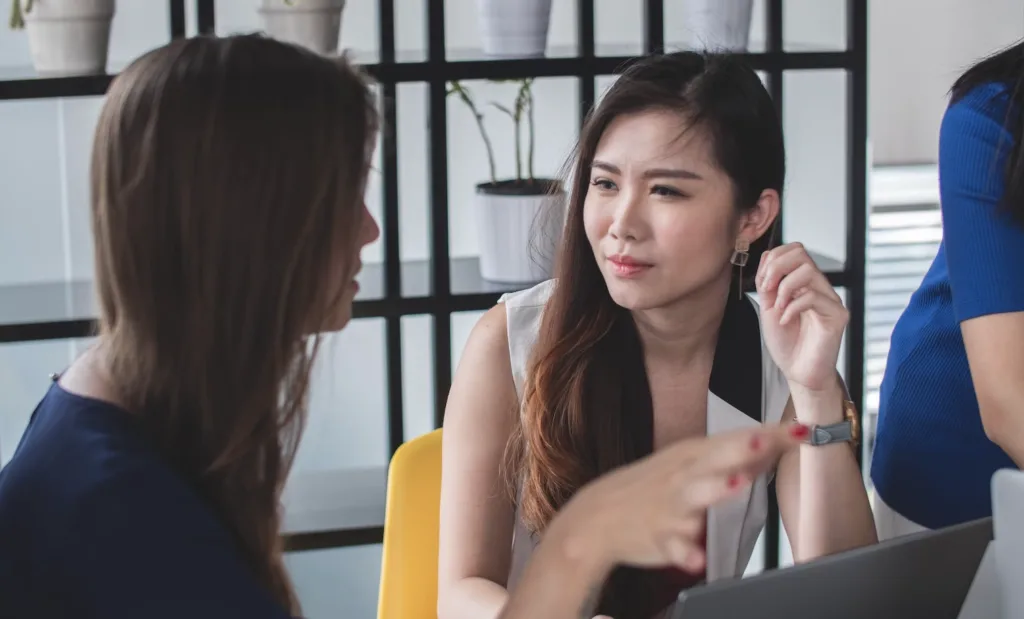 What Is Talent Development? 6 Key Benefits and 4 Activities 7 Two women in an office setting in deep conversation.