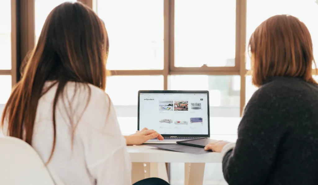 Peer Mentor Programs: How They Work and How to Start Them 6 Two women sitting in front of a computer in a peer mentoring relationship.