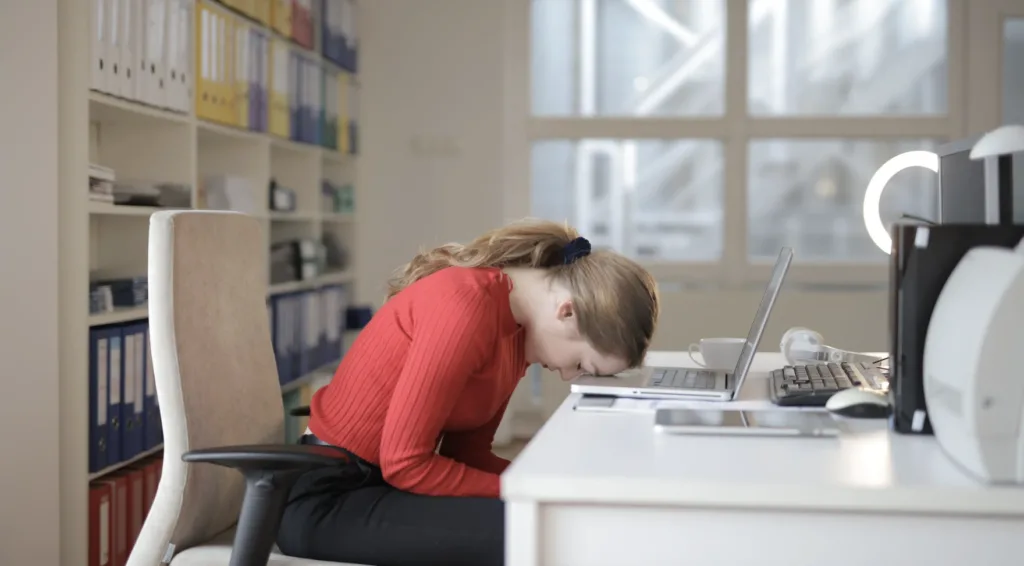 Employee Recognition: Why It's Important and How to Implement It 10 A worker gives up and puts her head on the computer, a reflection of the lack of employee recognition.