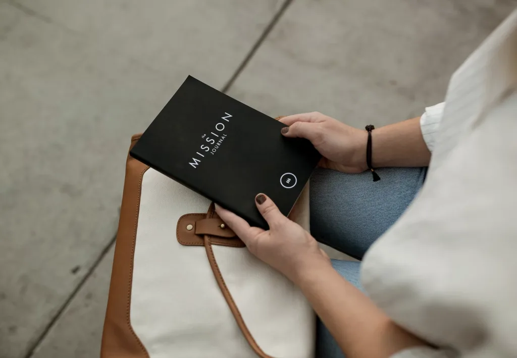 Mentoring Activities: Our 10 Favorite Mentoring Activities to Boost Engagement 8 A person holding a mission journal that will be used to write a vision statement as a mentoring activitiy.
