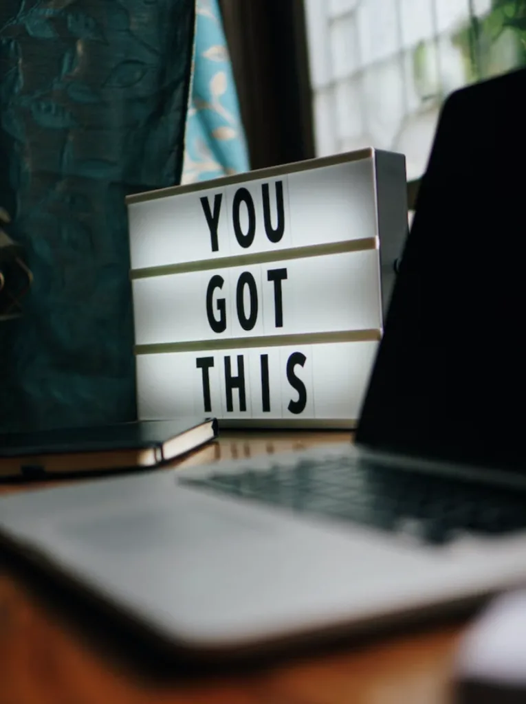 How to Set Priorities in Mentoring Relationships 5 A light up sign on an office desk that says You Got This next to a laptop.